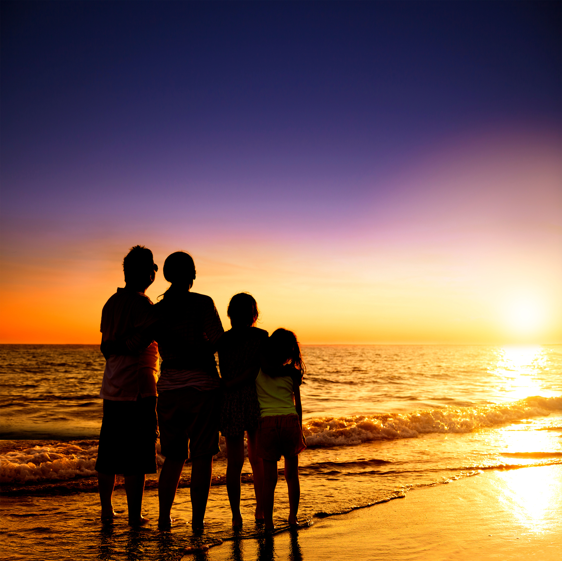 happy family watching the sunset on the beach